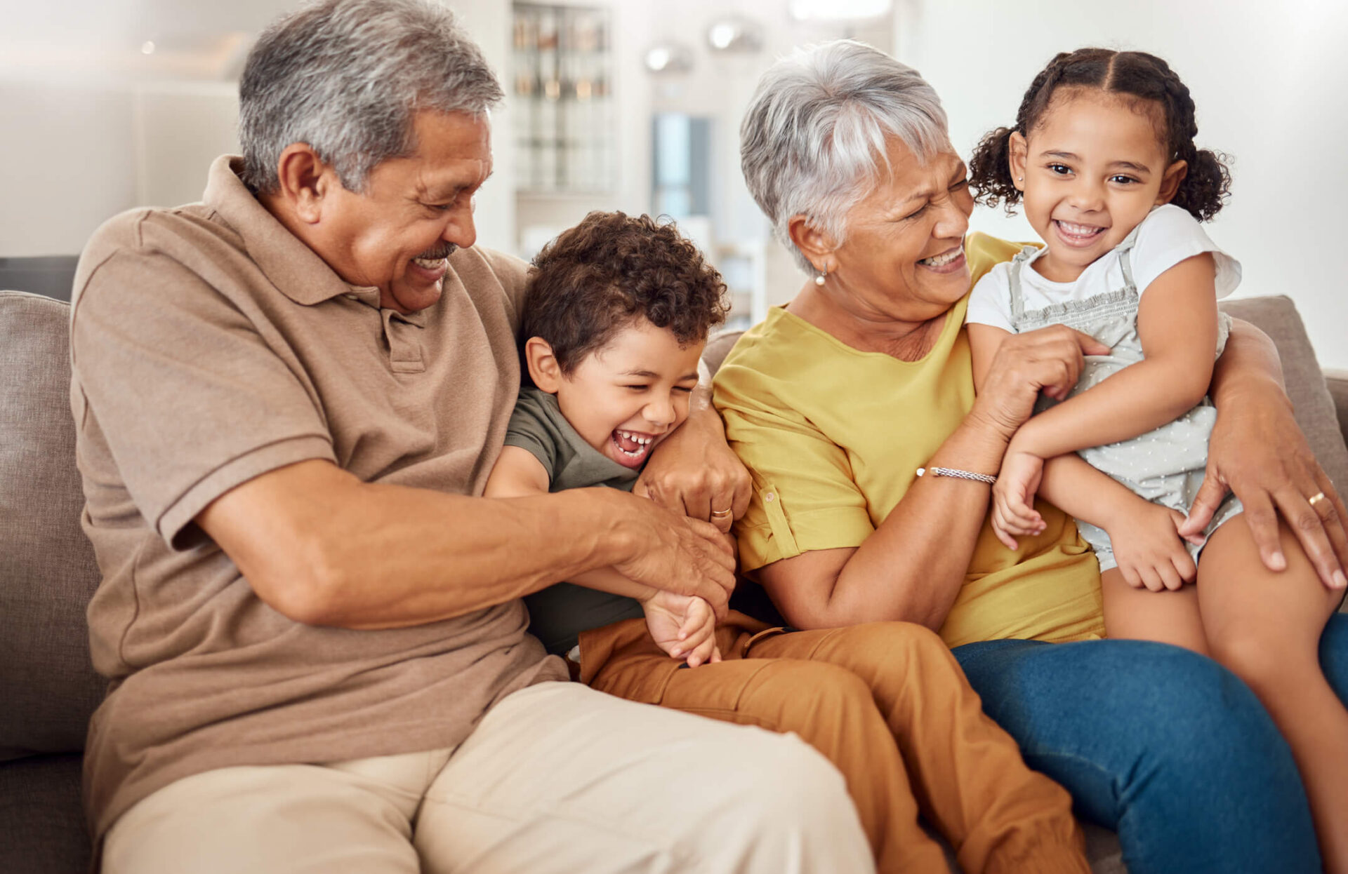 kinship parents and children on couch laughing and playing